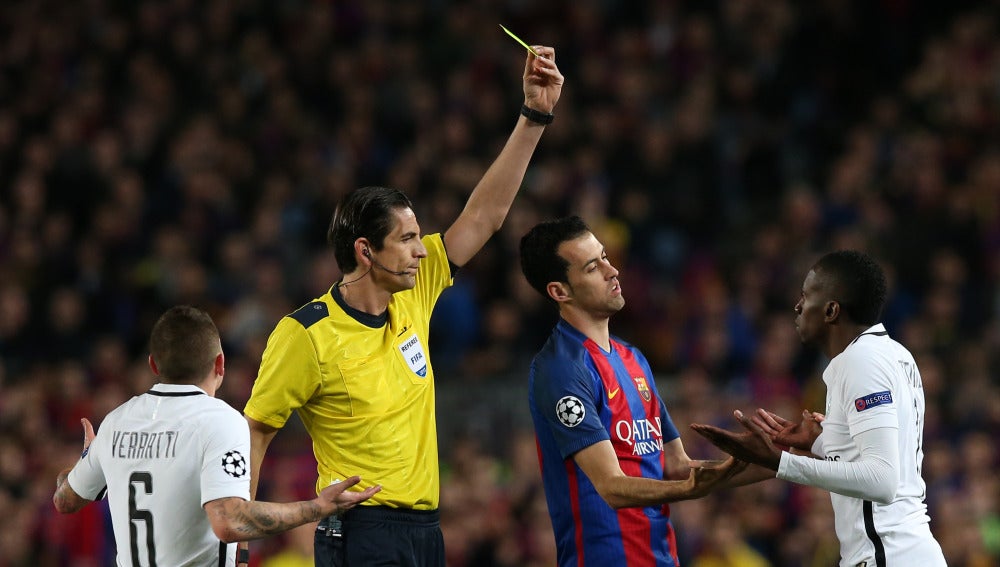 Aytekin muestra una tarjeta amarilla durante el Barcelona - PSG