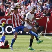 Mikel Vesga y Vitolo disputan el balón en el Sporting - Sevilla