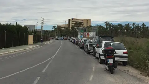Vehículos estacionados en la cuneta de una de las carretaras que da acceso al Hospital General de Elche -al fondo-. Hospital General Elche
