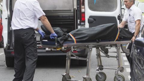 Operarios de la funeraria retirando el cad&aacute;ver