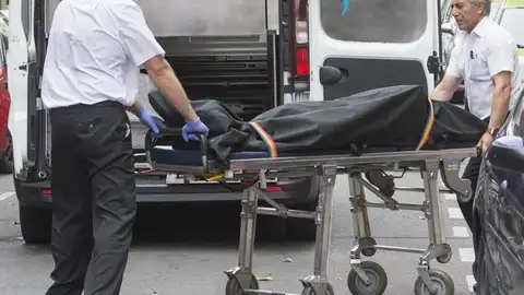 Operarios de la funeraria retirando el cadáver Operarios de la funeraria retirando el cadáver