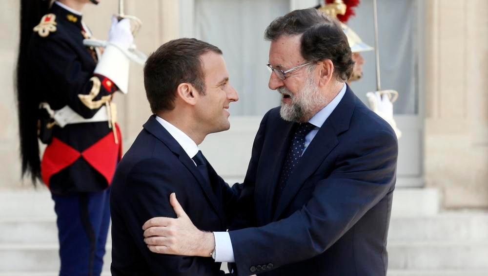 El presidente francés, Emmanuel Macron (i), da la bienvenida al jefe del Gobierno español, Mariano Rajoy
