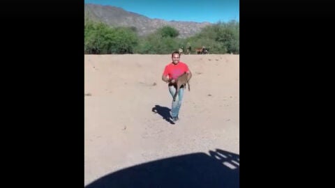 El hombre con la cabra en brazos