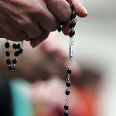 Una mujer con un rosario en la mano