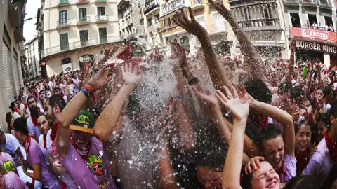 Chupinazo | San Fermín 2017 Un grupo de personas recibe agua desde un balcón durante la celebración del comienzo de las fiestas de San Fermín 2017.