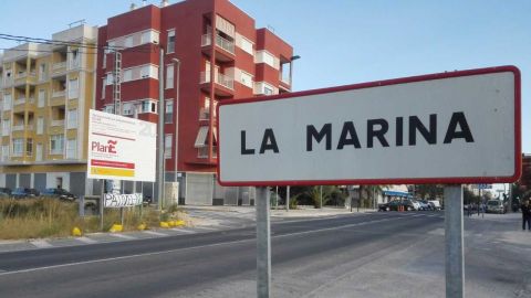 Acceso a la pedan&iacute;a de La Marina de Elche, con una pancarta contra el PATIVEL al fondo