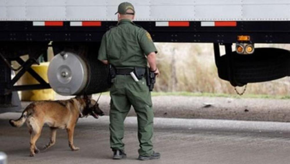 Un agente de la unidad canina de Texas vigila un camión en una foto de archivo
