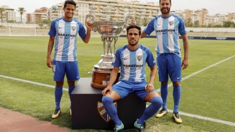 Los jugadores del M&aacute;laga Recio, Torres y Rosales, con el trofeo Costa del Sol