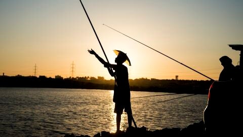 Un hombre pesca en el lago Mariout en la costa norte de Alejandr&iacute;a, Egipto.