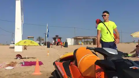 Un socorrista junto a una moto acuática de salvamento en las playas Un socorrista junto a una moto acuática de salvamento en las playas