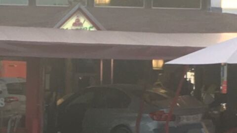 El coche, estrellado en la pizzeria. 