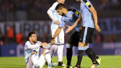 Su&aacute;rez ayuda a Messi a levantarse