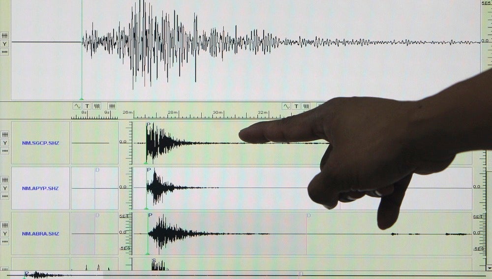 Un experto señala en un sismógrafo el registro de un terremoto