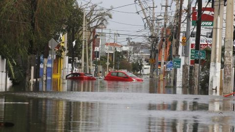  Dos coches flotan en una calle totalmente inundada en San Juan (Puerto Rico), tras el paso del hurac&aacute;n Mar&iacute;a.