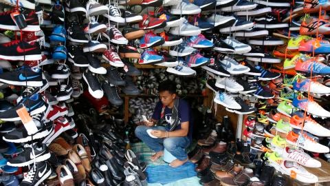 Un vendedor de calzado en un comercio de Indonesia 
