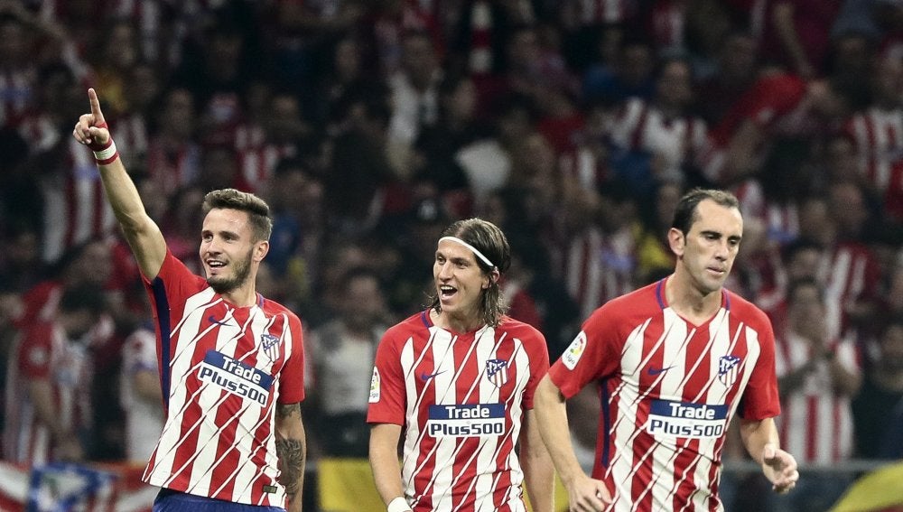 Saúl celebra con Filipe Luis y Godín un gol del Atlético