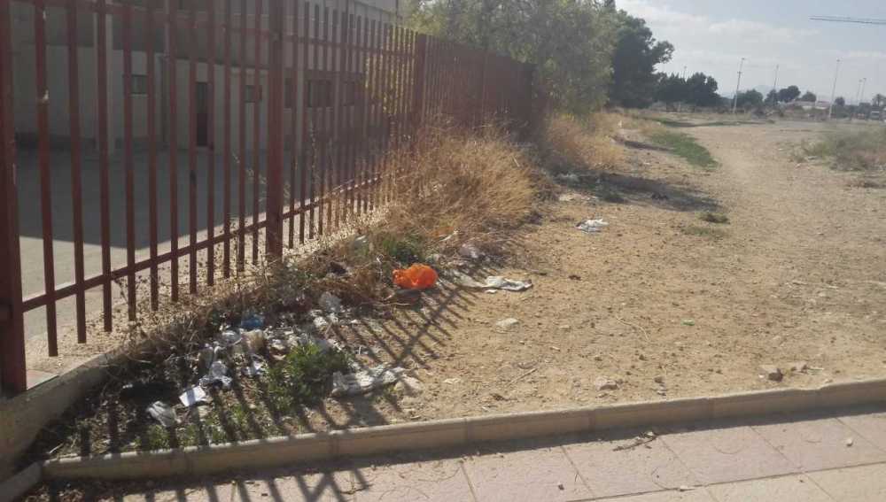 Bolsas de basura y otros residuos junto a la valla perimetral del colegio Julio Mar´´ia López Orozco de Elche