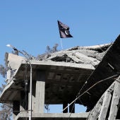 Una bandera de Daesh ondea sobre un edificio destruido cerca de la Plaza del Reloj de siria