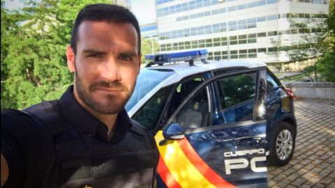 Sa&uacute;l Craviotto posa con su uniforme de Polic&iacute;a al lado de un coche patrulla