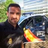 Saúl Craviotto posa con su uniforme de Policía al lado de un coche patrulla