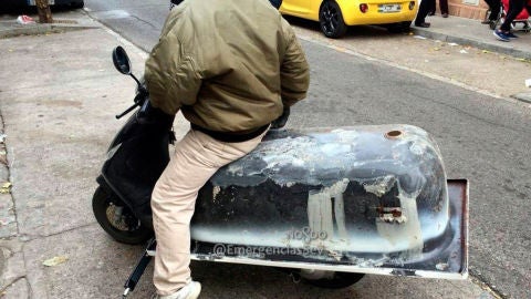 Un hombre conduciendo con una ba&ntilde;era en la moto