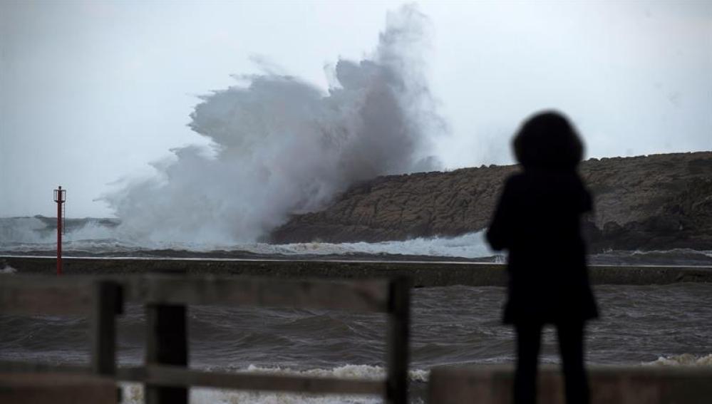 Una mujer observa cómo rompen las olas durante la borrasca 'Ana'