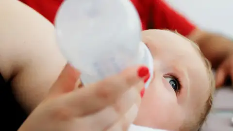 Un bebé tomando un biberón de leche leche_643x397