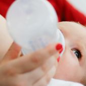 Un bebé tomando un biberón de leche