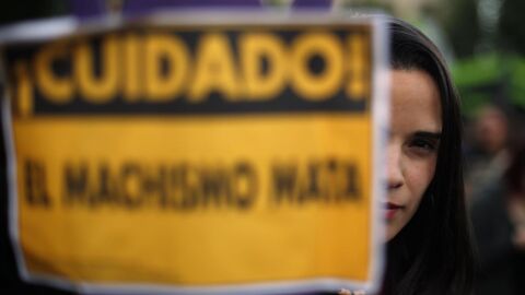 Una joven llevando un cartel contra el machismo
