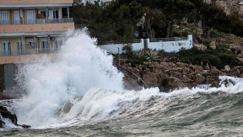 Una ola rompe contra unas rocas durante el temporal