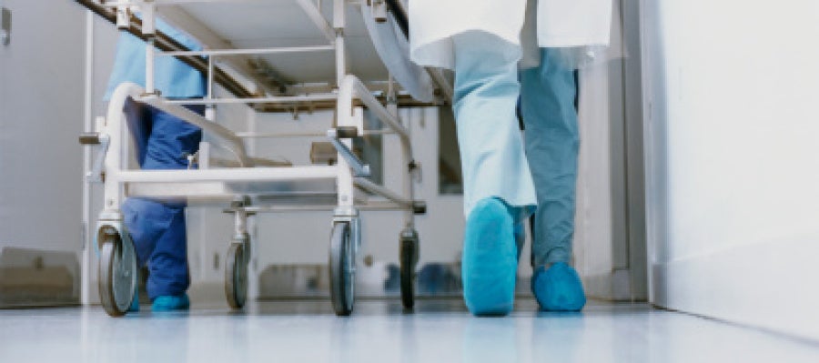 Un médico lleva una camilla en un hospital Un médico lleva una camilla en un hospital