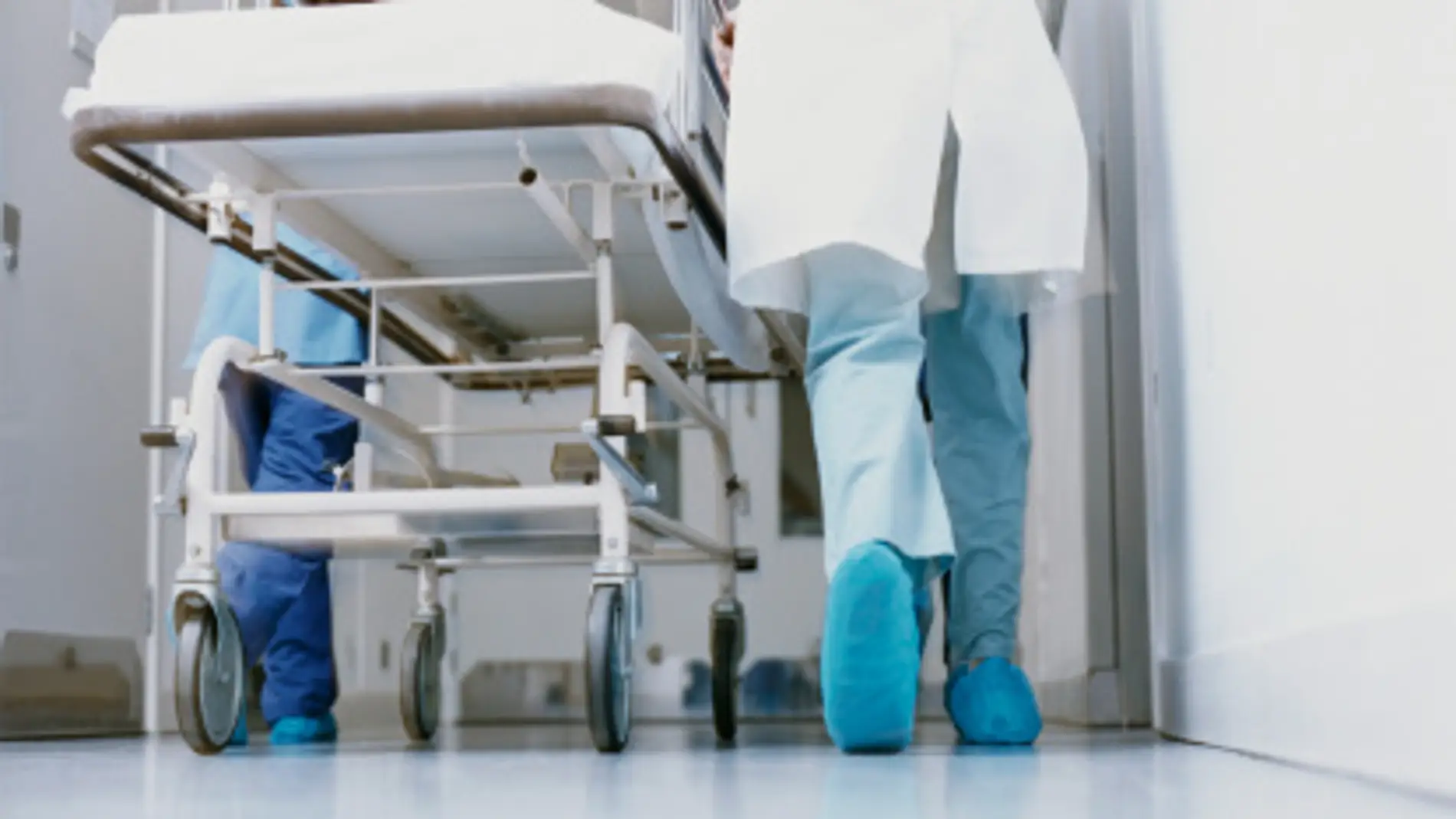 Un médico lleva una camilla en un hospital