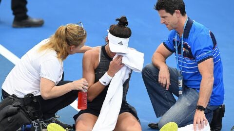 Garbi&ntilde;e Muguruza siendo atendida por las asistencias en Brisbane