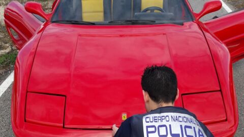 Un agente de la Polic&iacute;a Nacional junto al veh&iacute;culo modificado para ser vendido como un Ferrari