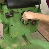 Un trabajador manipula una máquina en una fábrica