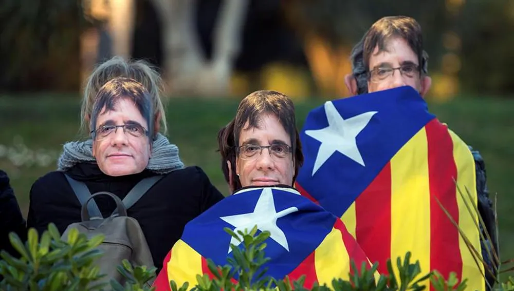 Gente con caretas de Puigdemont en los alrededores del Parlament