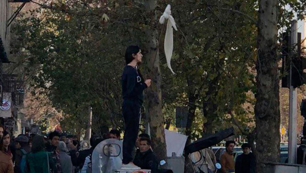 Una mujer se quita el velo durante una manifestación en Irán
