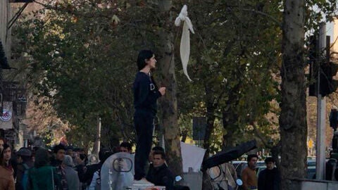 Una mujer se quita el velo durante una manifestaci&oacute;n en Ir&aacute;n