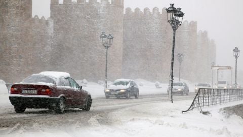 Varios veh&iacute;culos circulan por una carretera pr&oacute;xima a la muralla de &Aacute;vila 