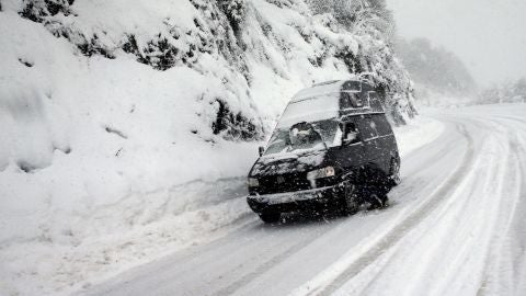 Un hombre coloca cadenas a su veh&iacute;culo hoy en el puerto de Pajares (Asturias)