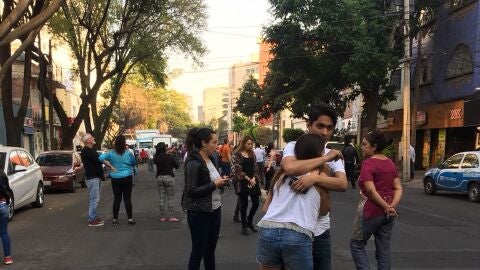 Personas esperan afuera de sus oficinas y veh&iacute;culos tras el sismo registrado