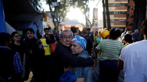 Dos personas se abrazan tras sentir el terremoto que ha sacudido M&eacute;xico