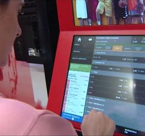 Una mujer usa una máquina de apuestas Una mujer usa una máquina de apuestas