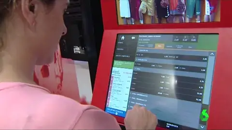Una mujer usa una máquina de apuestas Una mujer usa una máquina de apuestas