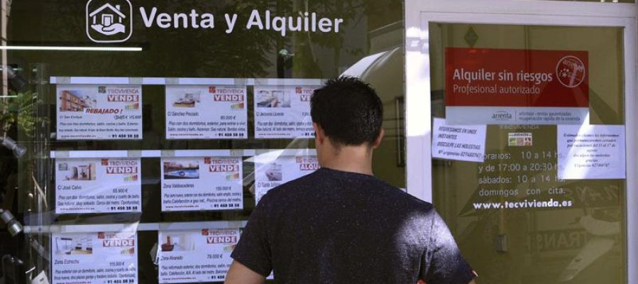 Un hombre mira los pisos en venta de una inmobiliaria Un hombre mira los pisos en venta de una inmobiliaria