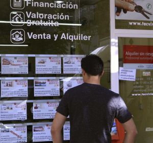 Un hombre mira los pisos en venta de una inmobiliaria Un hombre mira los pisos en venta de una inmobiliaria