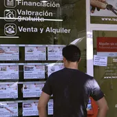 Un hombre mira los pisos en venta de una inmobiliaria Un hombre mira los pisos en venta de una inmobiliaria