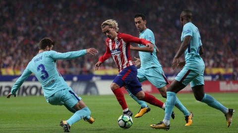 Griezmann intenta avanzar ante la defensa del Barcelona
