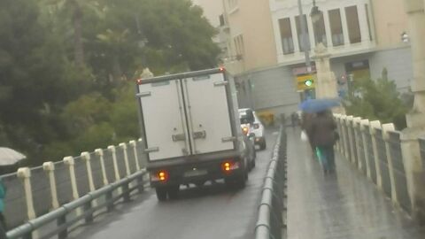 Personas con paraguas en el Puente de Canalejas de Elche