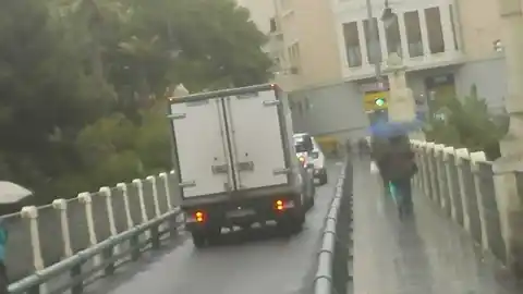 Personas con paraguas en el Puente de Canalejas de Elche Personas con paraguas en el Puente de Canalejas de Elche